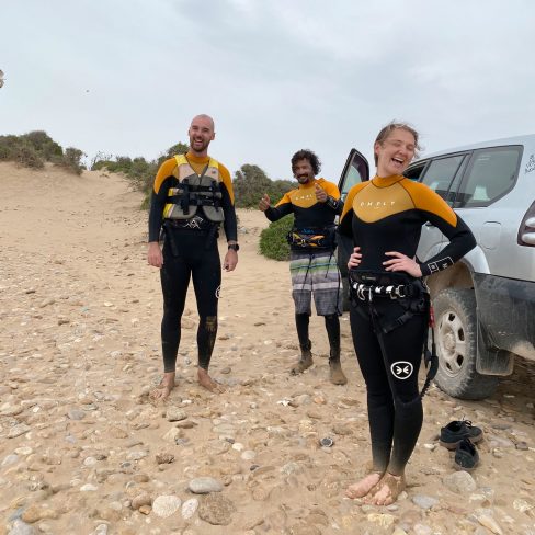 a couple smiling with their teacher of finishing their kite surf lesson in Sidi Kaouki Marocco