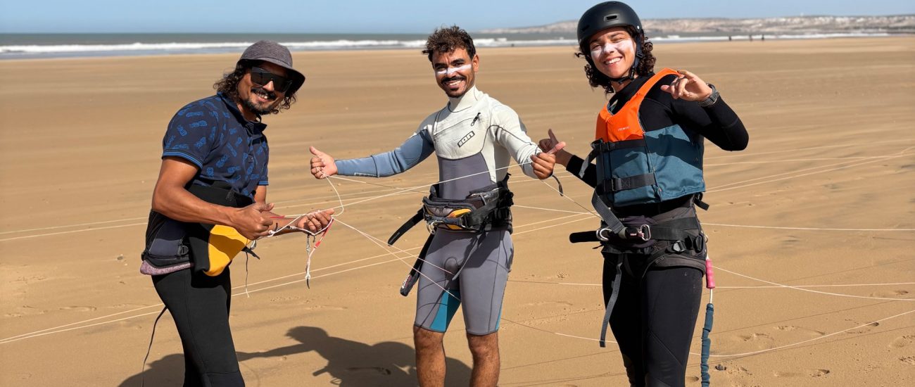 a girl smiling with her teachers after finishing her kite surf lesson in Sidi Kaouki Marocco