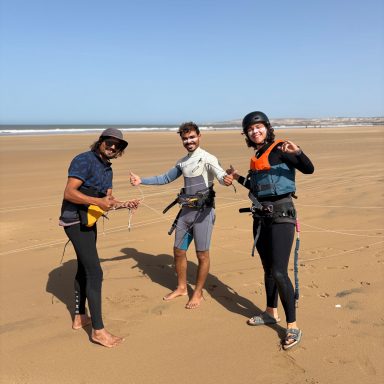 a girl smiling with her teachers after finishing her kite surf lesson in Sidi Kaouki Marocco