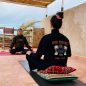 Two girls doing Yoga in Sidi Kaouki on a roof top in Momo Surf Camp